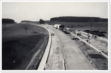 Blick &uuml;ber die Baustelle in bei Tanna in Richtung Berlin. Im Hintergrund ist der Mittelpfeiler des &Uuml;berf&uuml;hrungsbauwerks der Verbindungsstra&szlig;e Schilbach - Wernsdorf zu erkennen April 1936